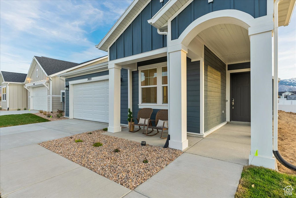 Entrance to property featuring a garage and covered porch
