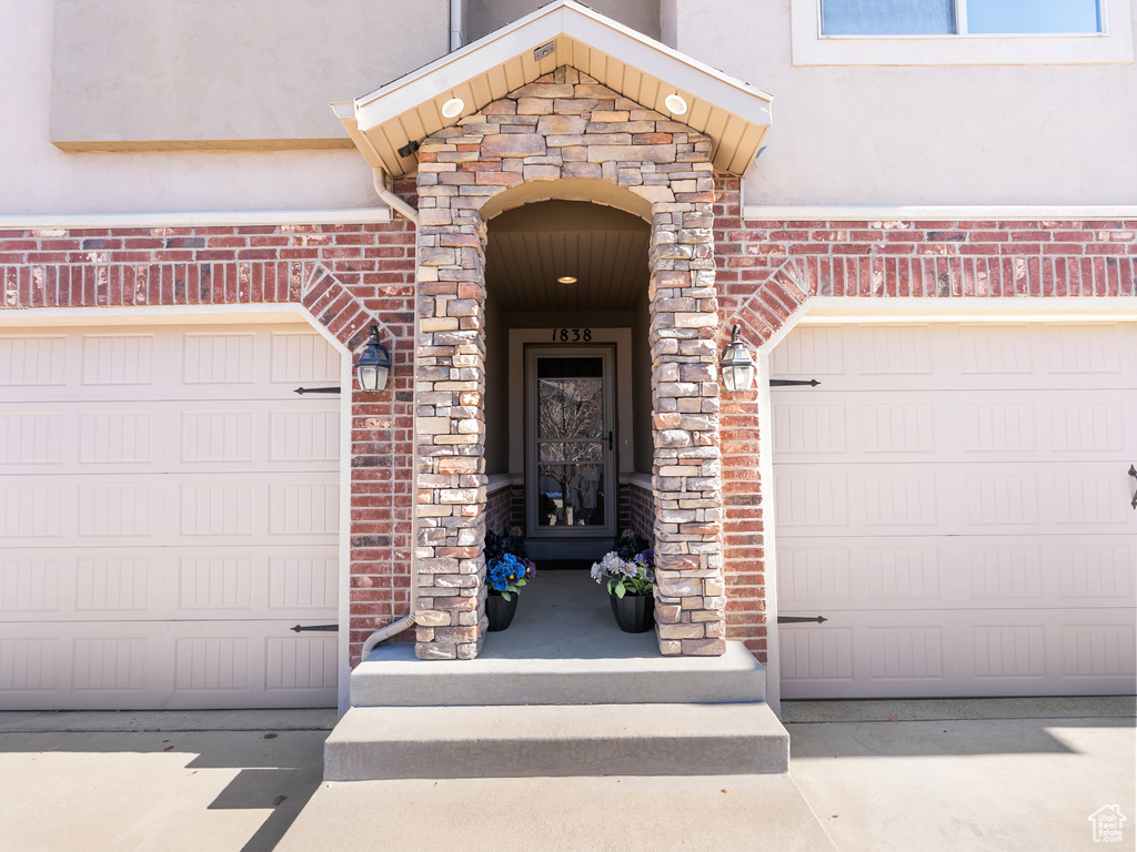 Doorway to property with a garage