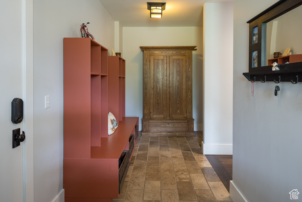 Hallway with baseboards and stone tile flooring