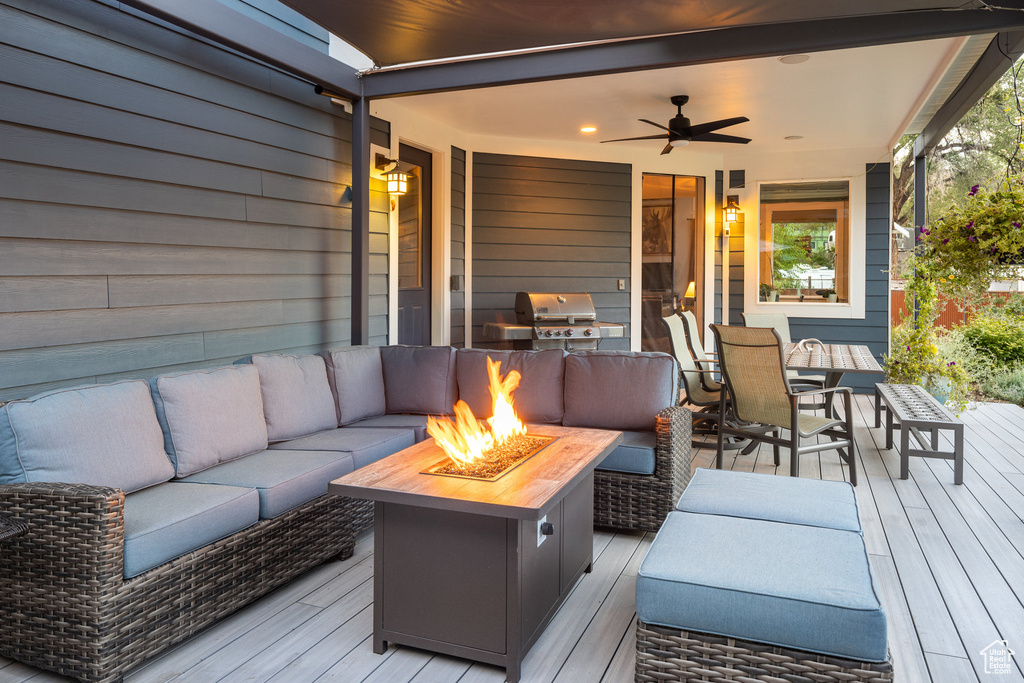 Wooden deck featuring a ceiling fan, an outdoor living space with a fire pit, outdoor dining area, and grilling area
