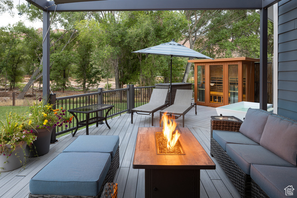 Wooden deck featuring an outdoor living space with a fire pit