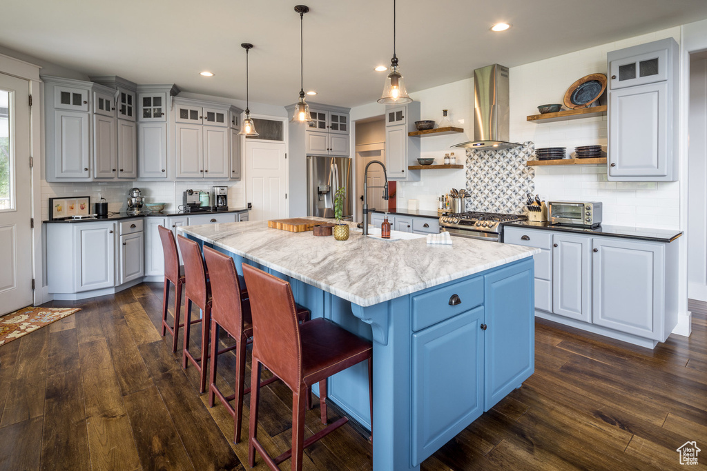 Kitchen with open shelves, decorative backsplash, dark wood-style floors, ventilation hood, and stainless steel appliances