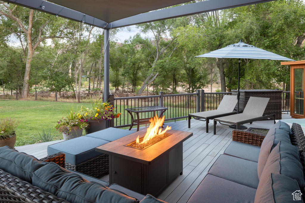 Deck with a lawn and an outdoor living space with a fire pit
