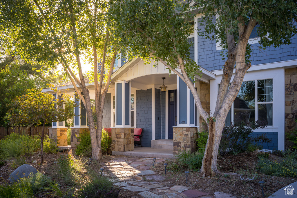 View of front facade featuring covered porch and stone siding