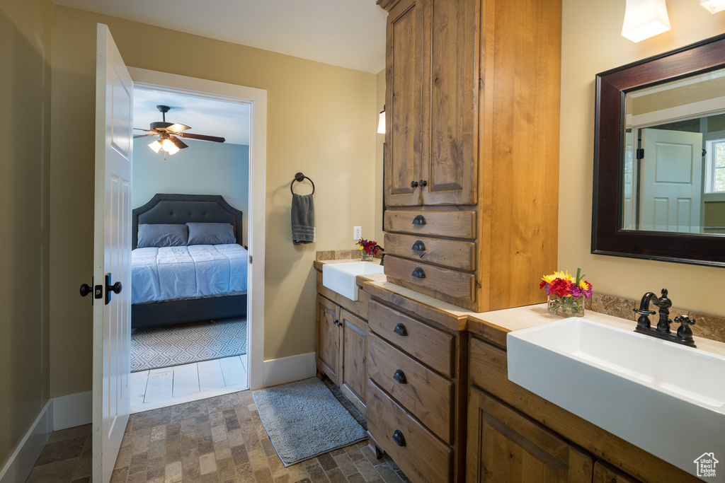 Bathroom featuring a sink, ensuite bathroom, a ceiling fan, and double vanity
