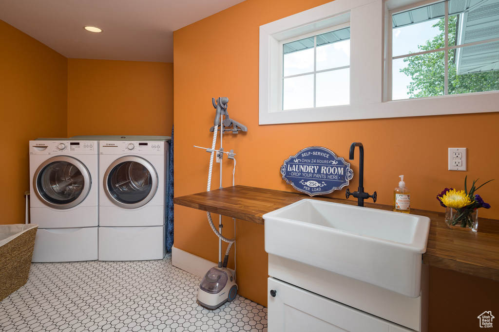 Laundry room featuring a sink, separate washer and dryer, plenty of natural light, and laundry area