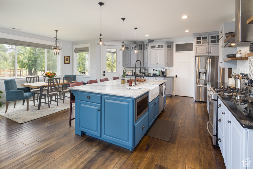 Kitchen featuring blue cabinets, dark wood finished floors, a sink, stainless steel appliances, and recessed lighting