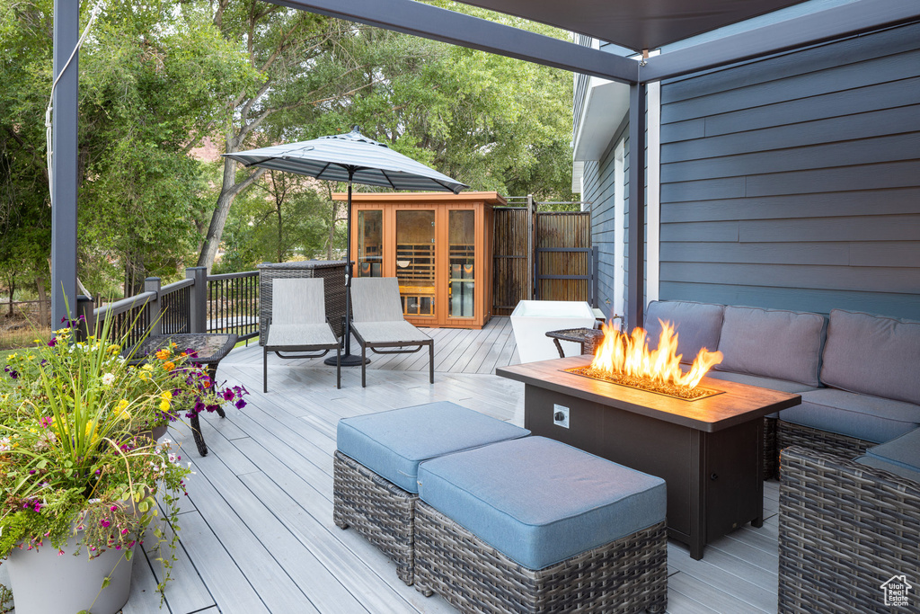 Wooden terrace with an outdoor living space with a fire pit