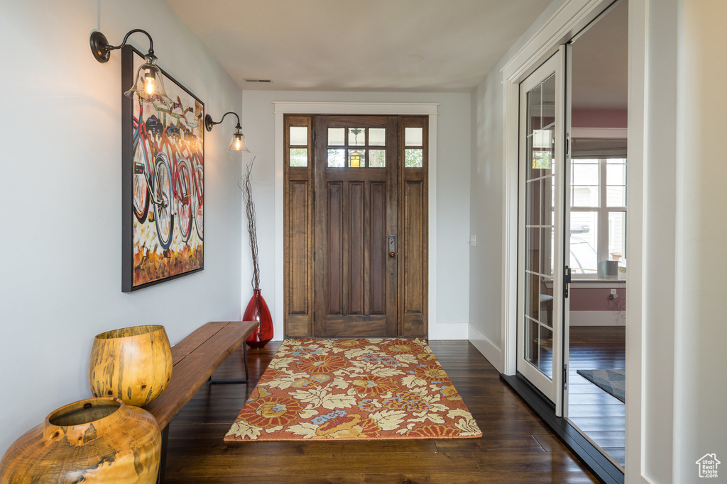 Entryway featuring baseboards, dark wood finished floors, a healthy amount of sunlight, and visible vents