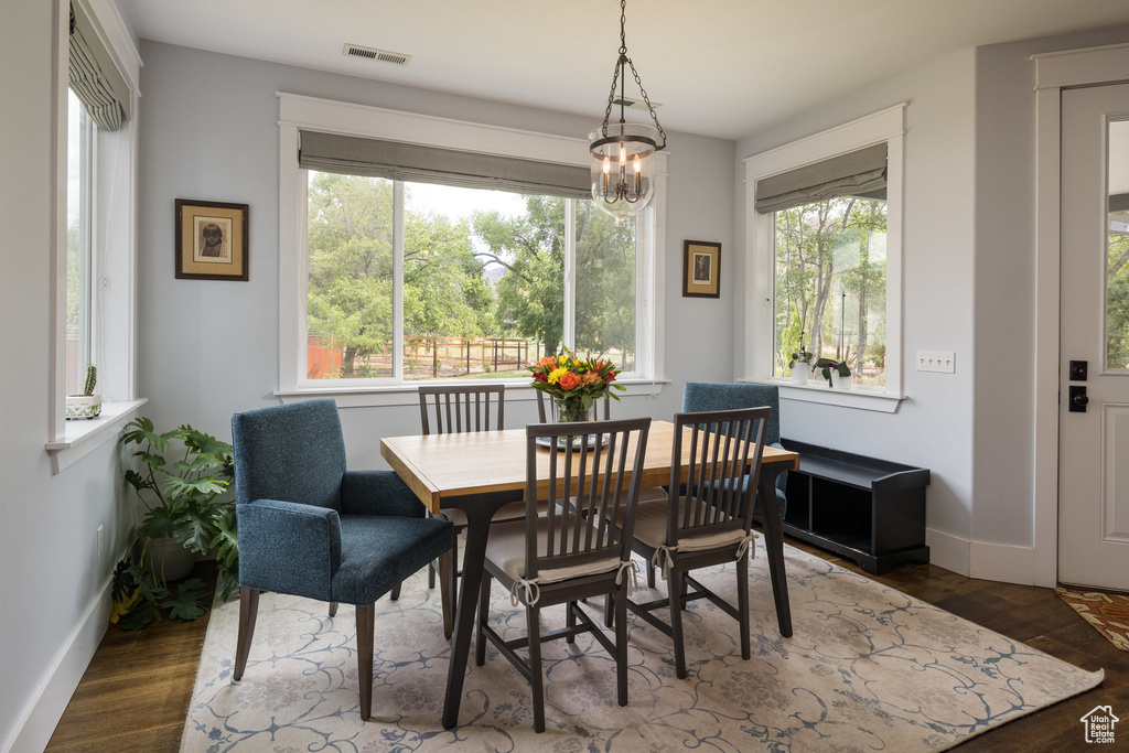 Dining space with a wealth of natural light, wood finished floors, and visible vents