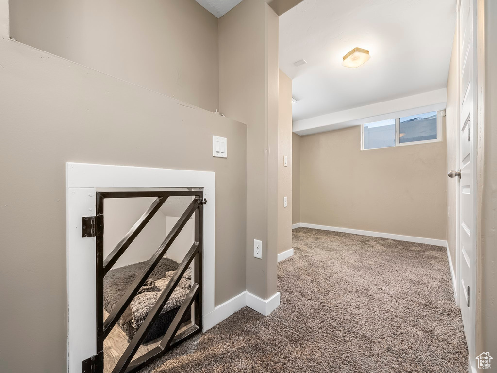 Hall featuring dark colored carpet