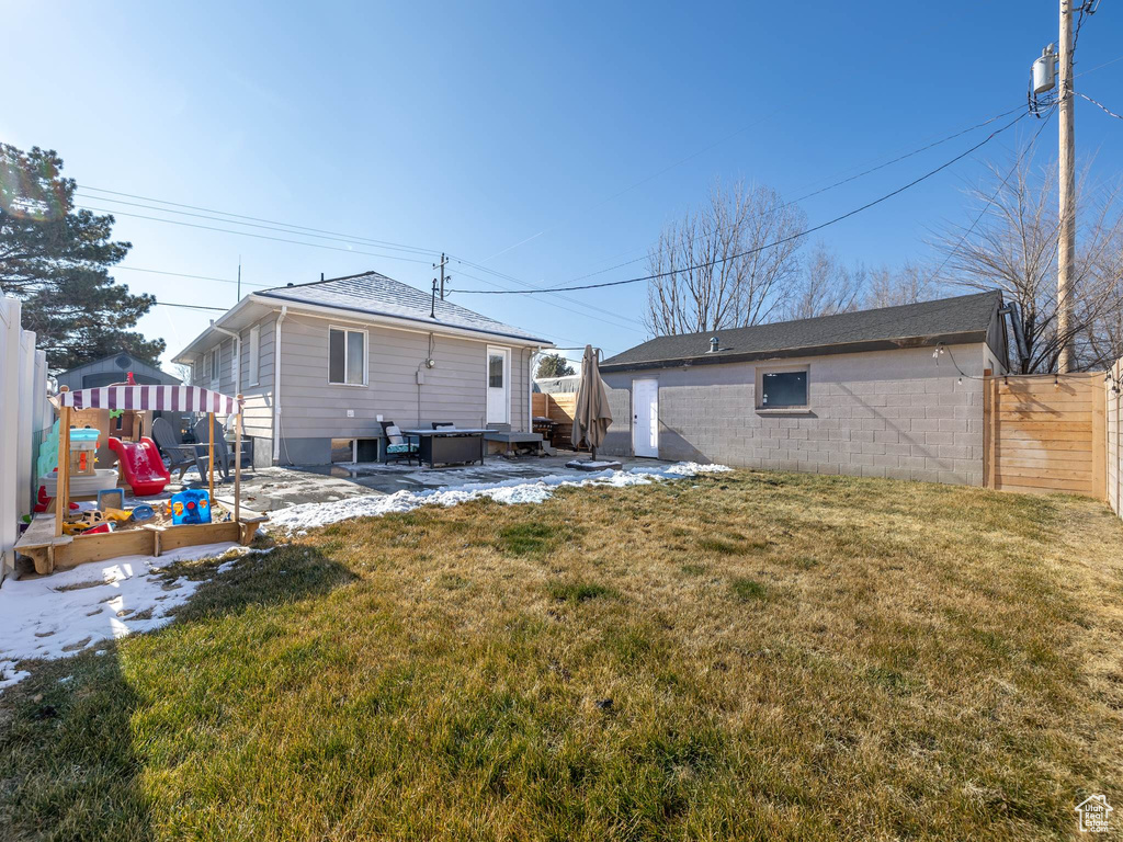 Rear view of property with a yard, a playground, and a jacuzzi