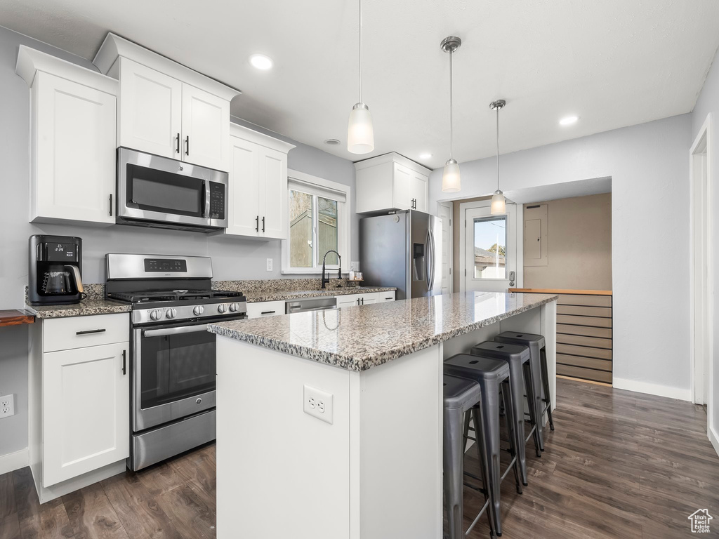 Kitchen featuring white cabinetry, stainless steel appliances, and a center island