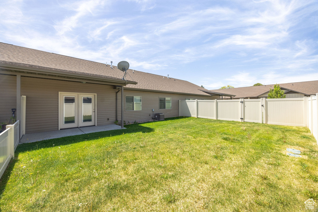 Rear view of house with a gate and central air condition unit