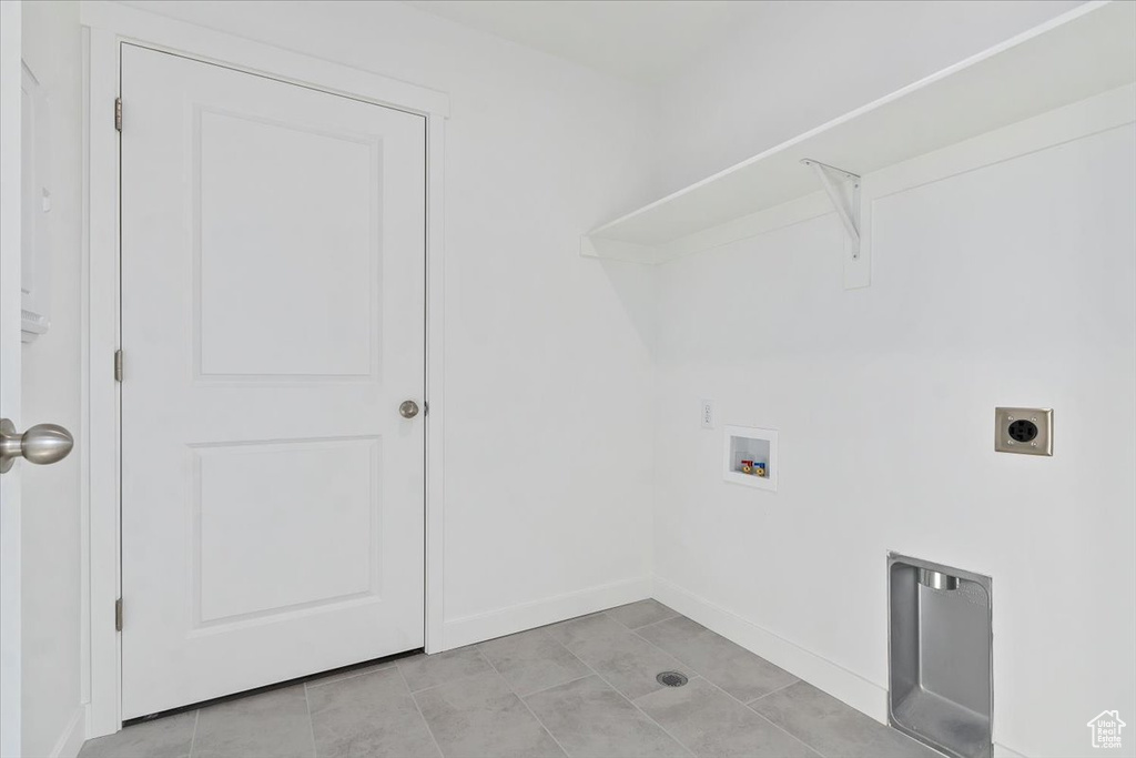 Laundry room with hookup for a washing machine, hookup for an electric dryer, and light tile patterned flooring