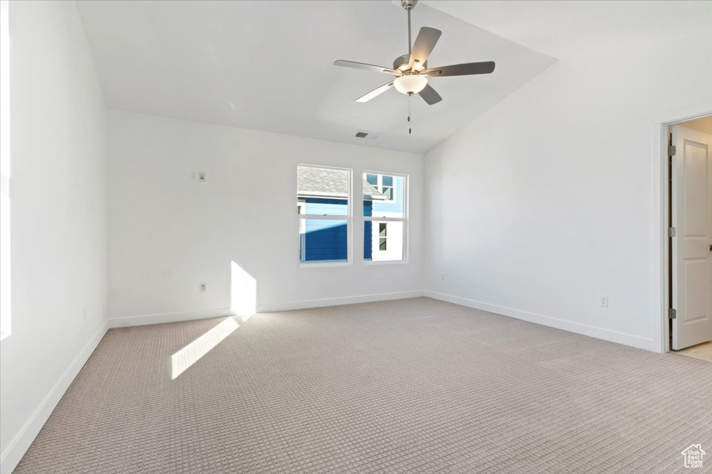 Unfurnished room with lofted ceiling, light colored carpet, and ceiling fan
