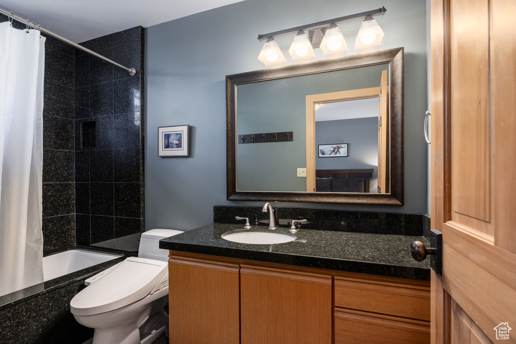 Full bathroom with vanity, toilet, and shower / bath combo