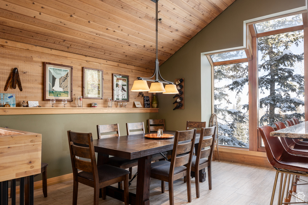 Dining room featuring wood ceiling, plenty of natural light, vaulted ceiling, and light hardwood / wood-style flooring
