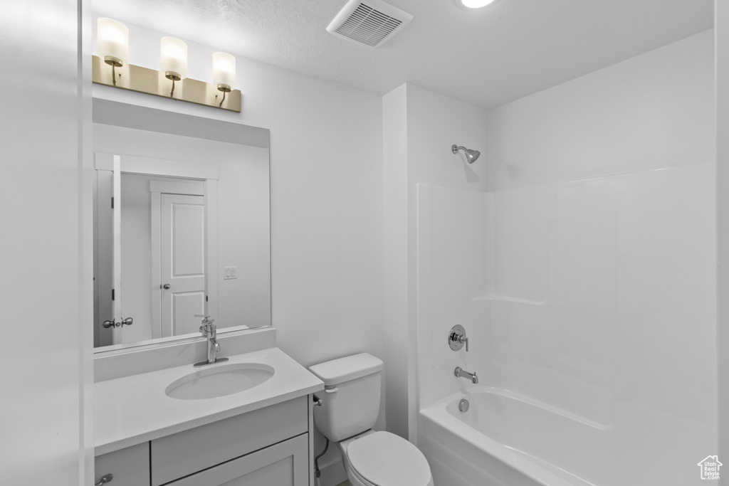 Full bathroom with vanity, shower / bathtub combination, and toilet