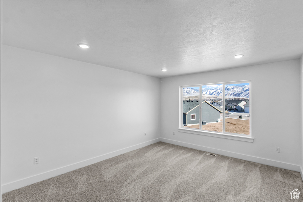 Spare room with a textured ceiling and carpet