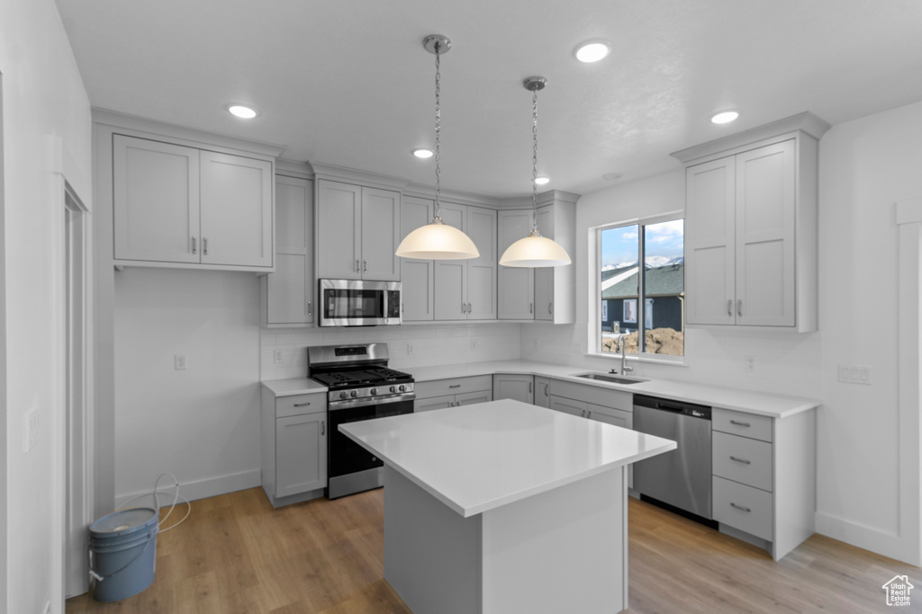Kitchen featuring sink, gray cabinets, stainless steel appliances, and a kitchen island