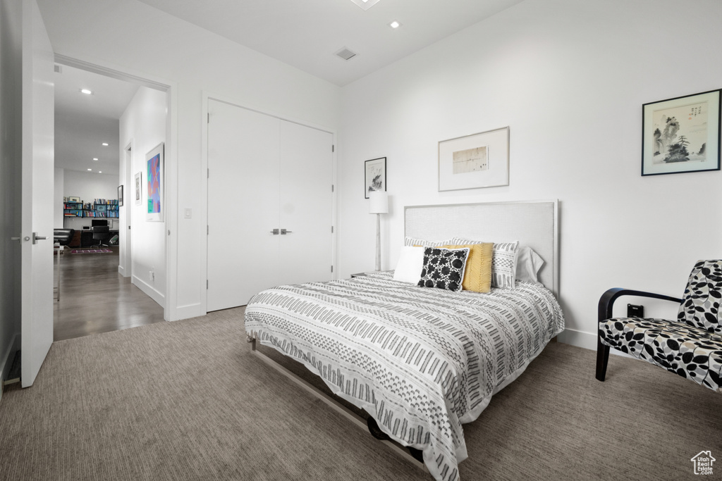 Bedroom featuring dark carpet and a closet