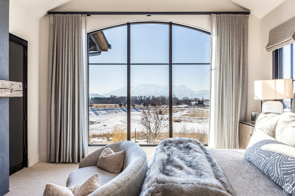 Carpeted bedroom featuring a mountain view and lofted ceiling