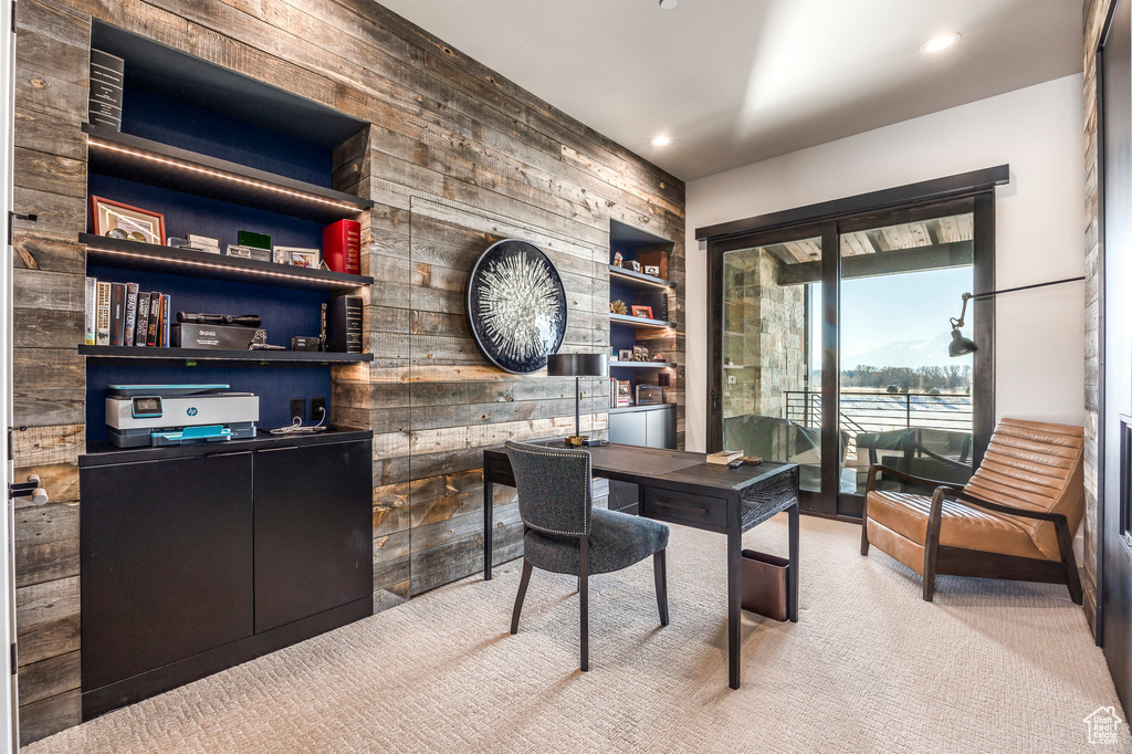 Carpeted office space featuring wood walls and recessed lighting