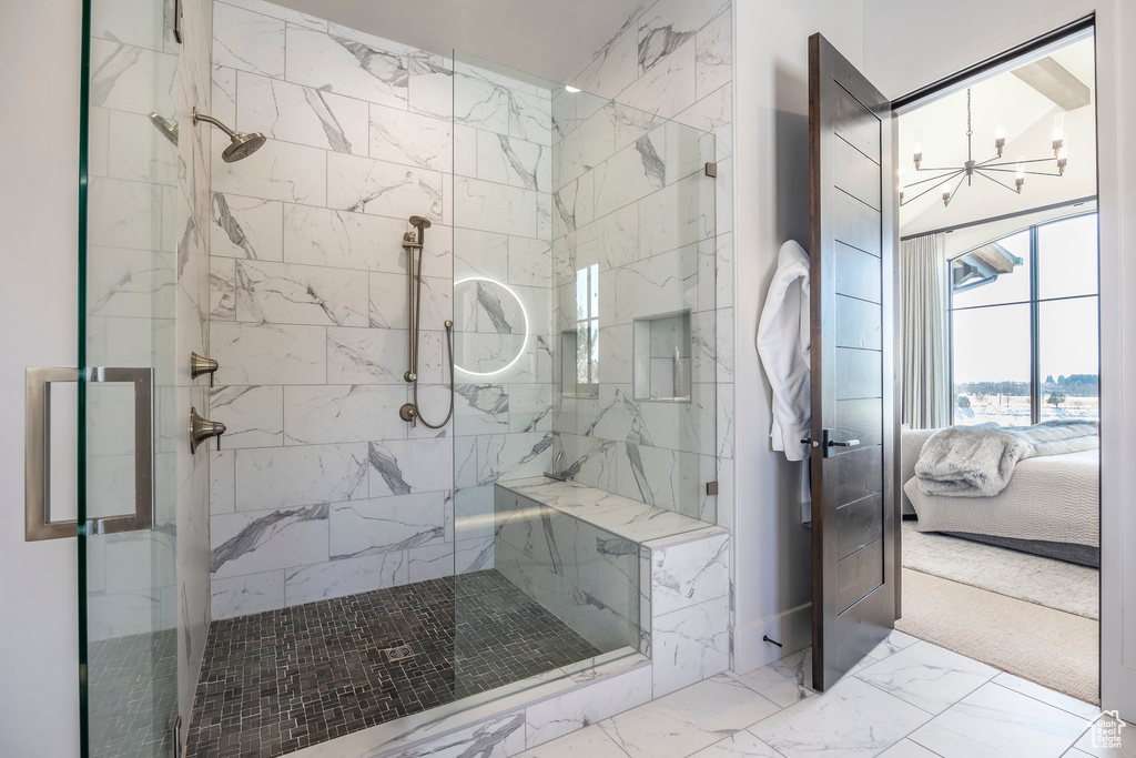 Full bath with connected bathroom, marble finish floors, a chandelier, and a marble finish shower
