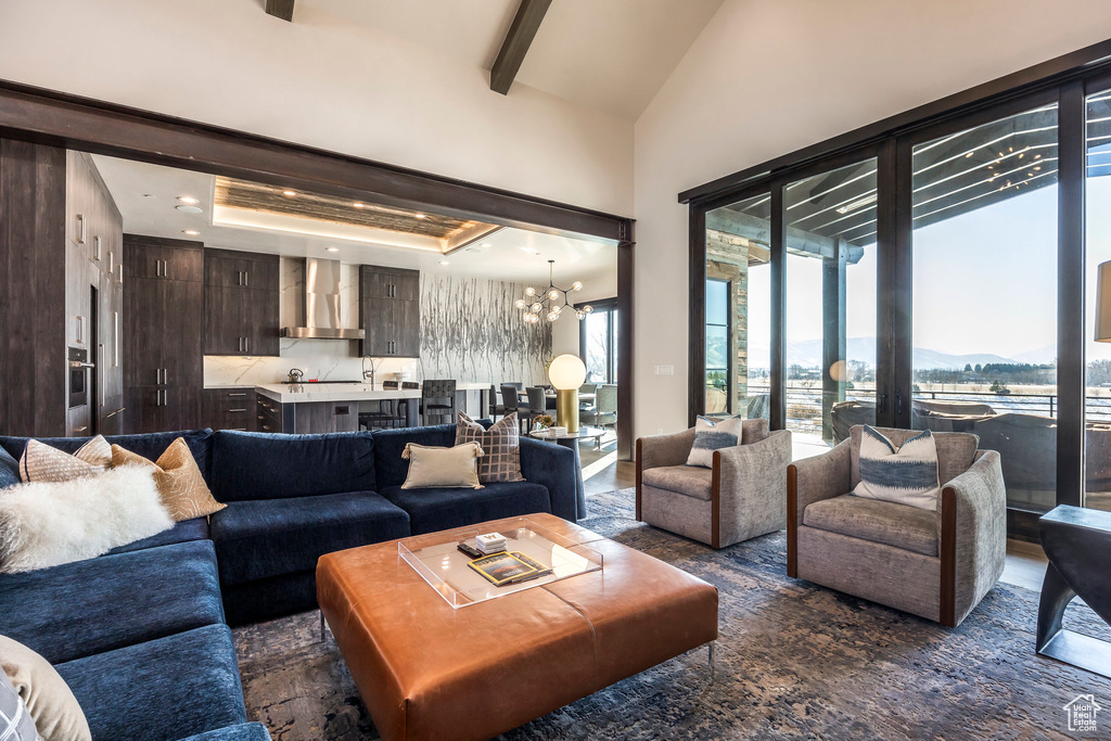 Living area with a chandelier, a mountain view, high vaulted ceiling, and beam ceiling