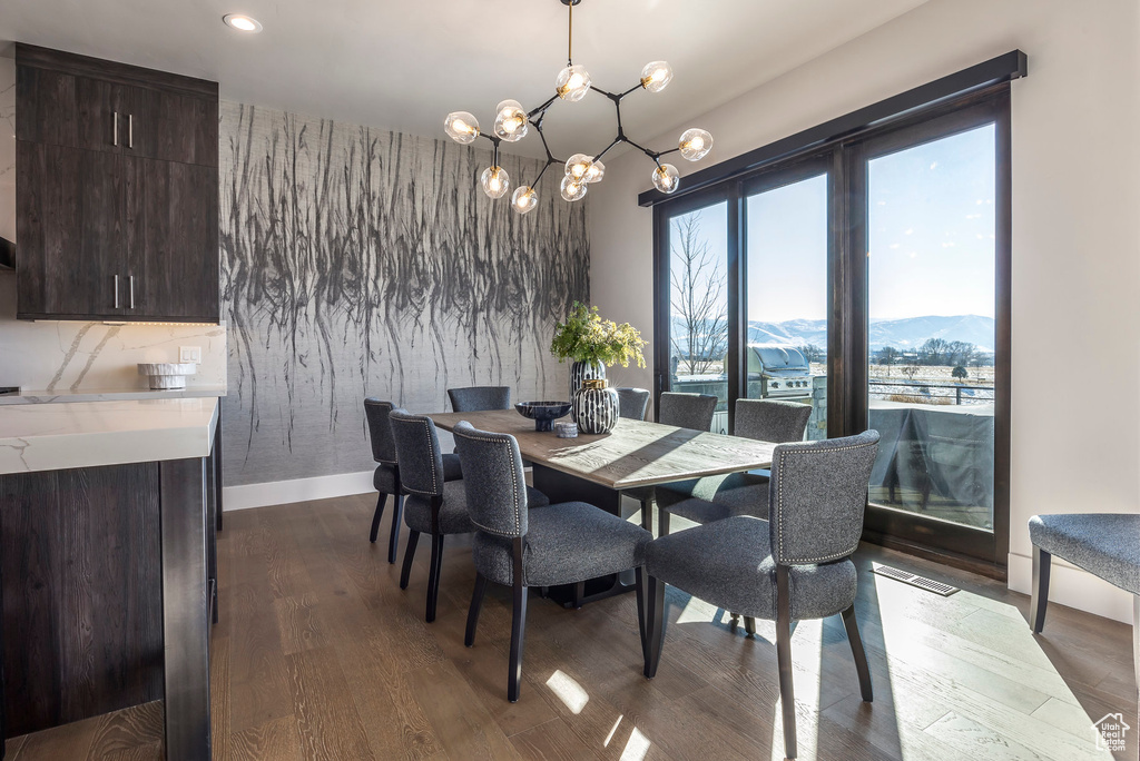 Dining space featuring a mountain view, dark wood-style flooring, a chandelier, baseboards, and recessed lighting
