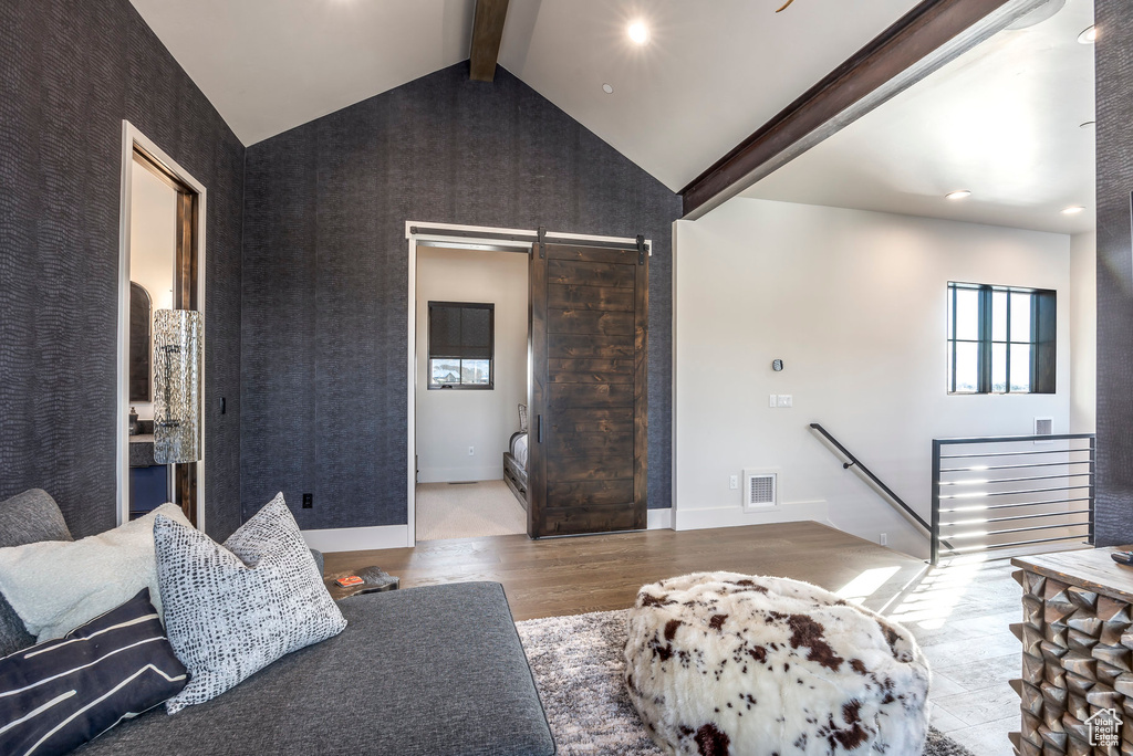 Living area featuring a barn door, wood finished floors, and recessed lighting