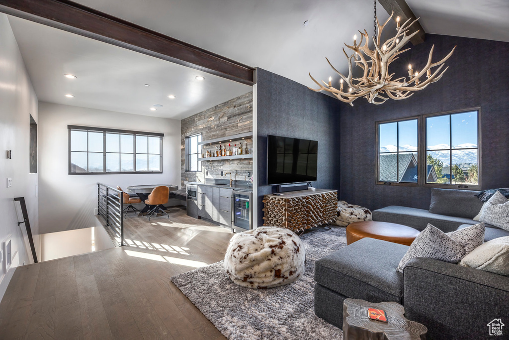 Living area featuring wood finished floors, beverage cooler, a chandelier, recessed lighting, and plenty of natural light
