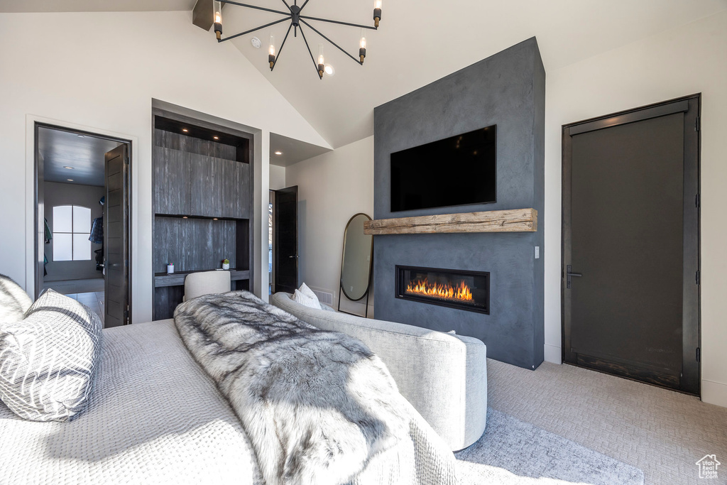 Bedroom featuring carpet, a glass covered fireplace, a chandelier, high vaulted ceiling, and recessed lighting