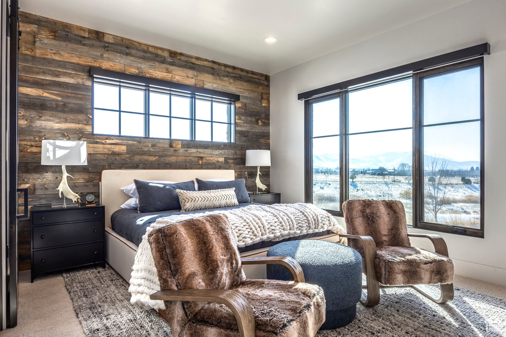 Carpeted bedroom with wood walls, a mountain view, and recessed lighting