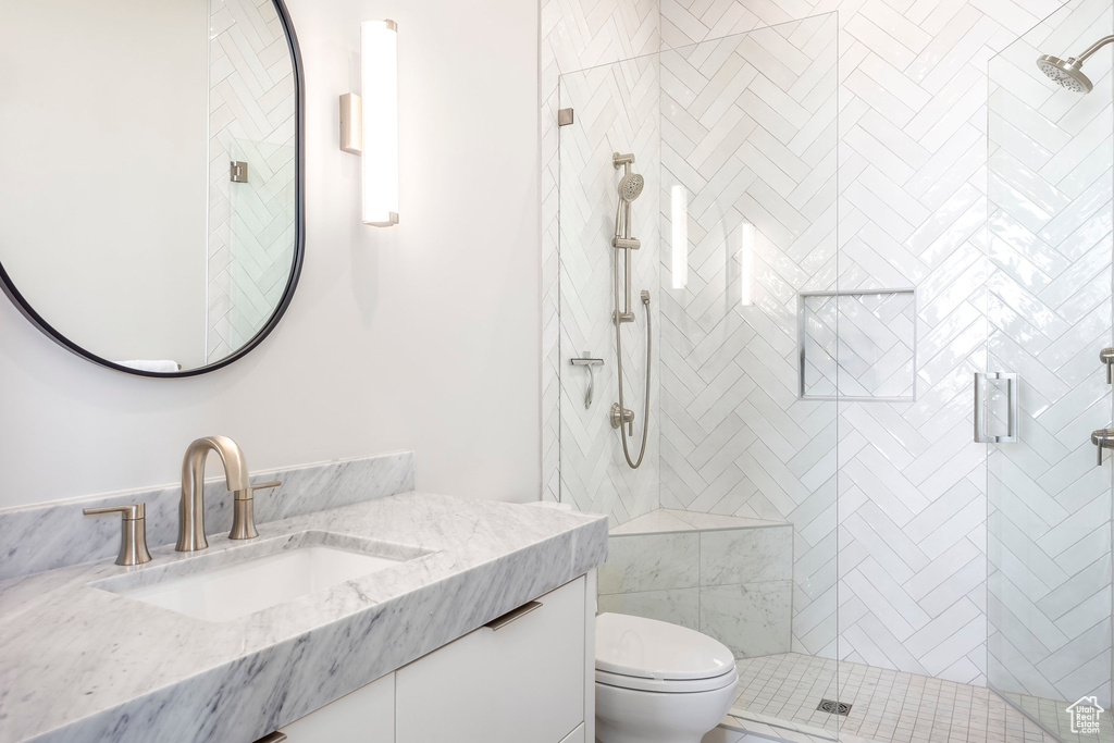 Full bathroom with toilet, a shower stall, and vanity