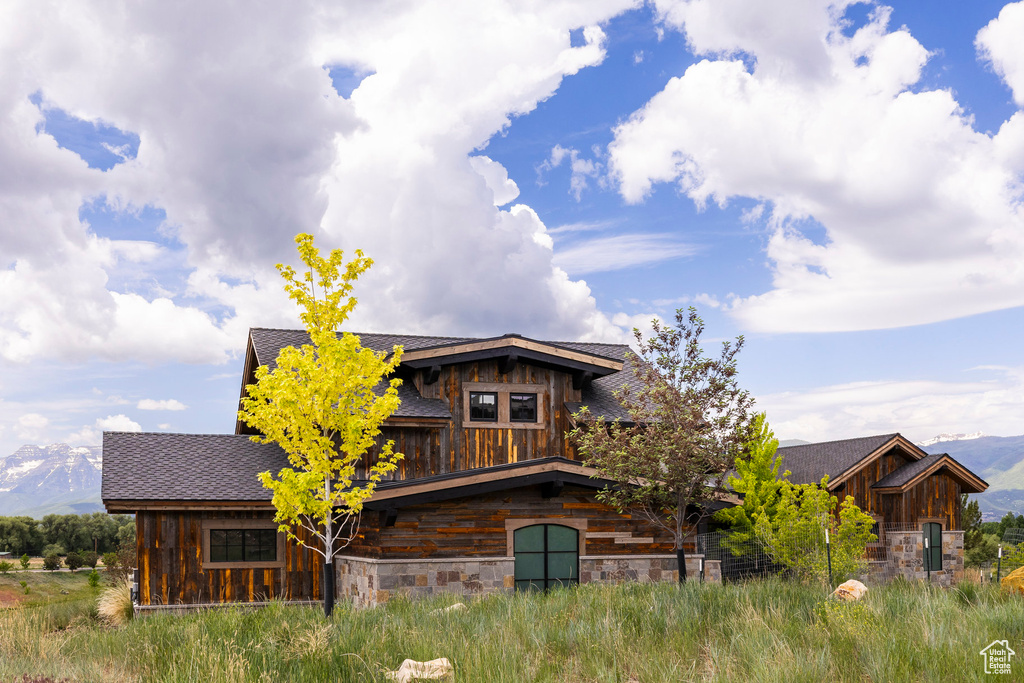 View of front facade featuring board and batten siding, stone siding, and a mountain view
