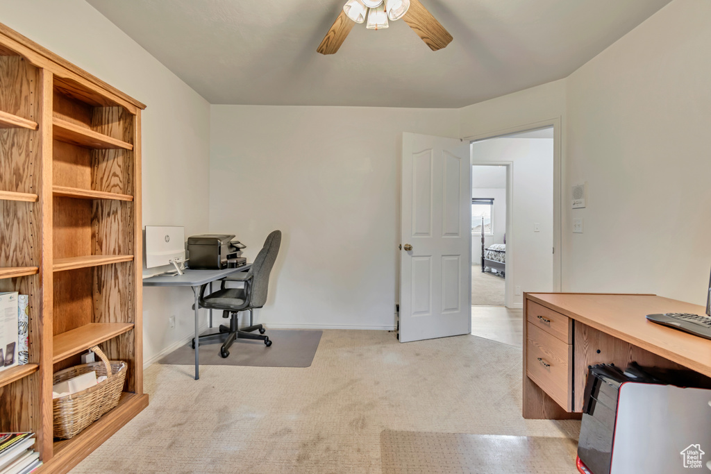 Office featuring ceiling fan, light carpet, and baseboards