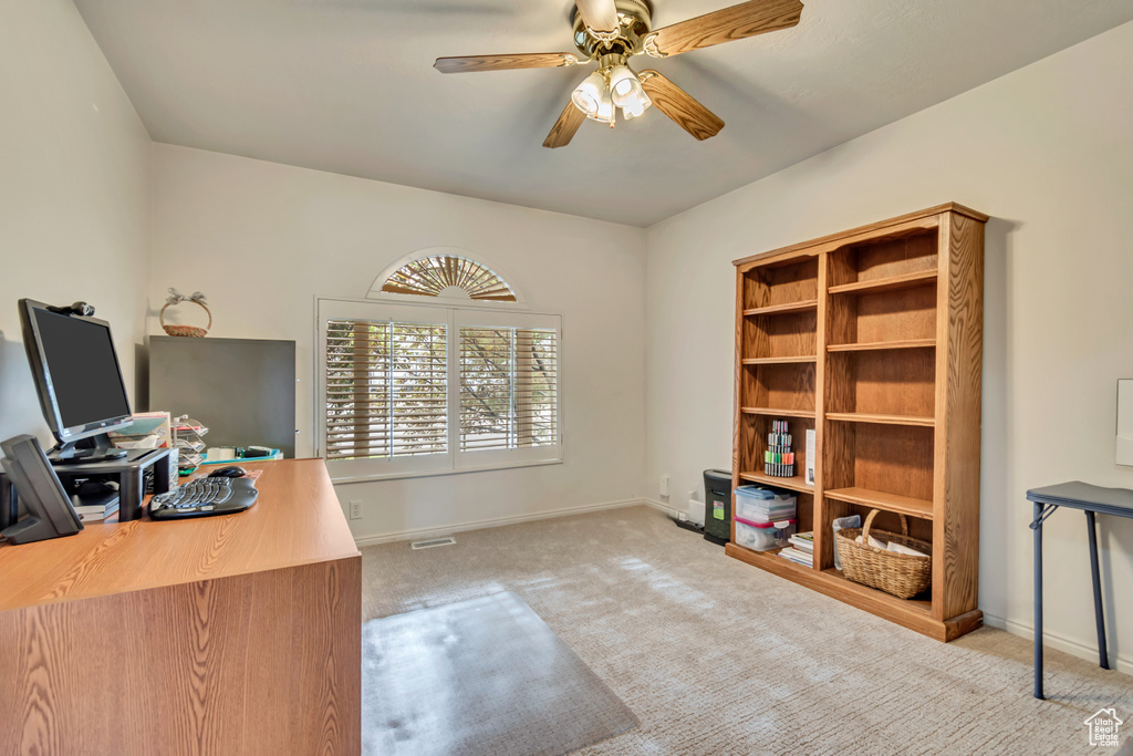 Carpeted office featuring ceiling fan and baseboards