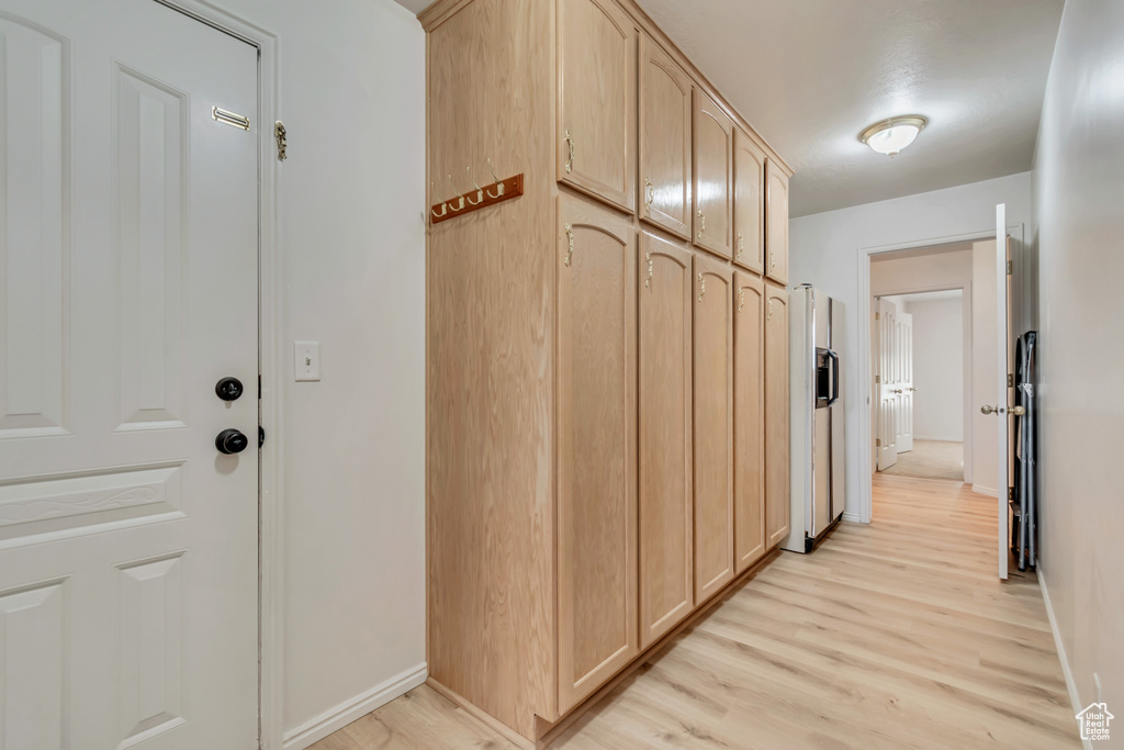 Corridor featuring light wood-style flooring and baseboards