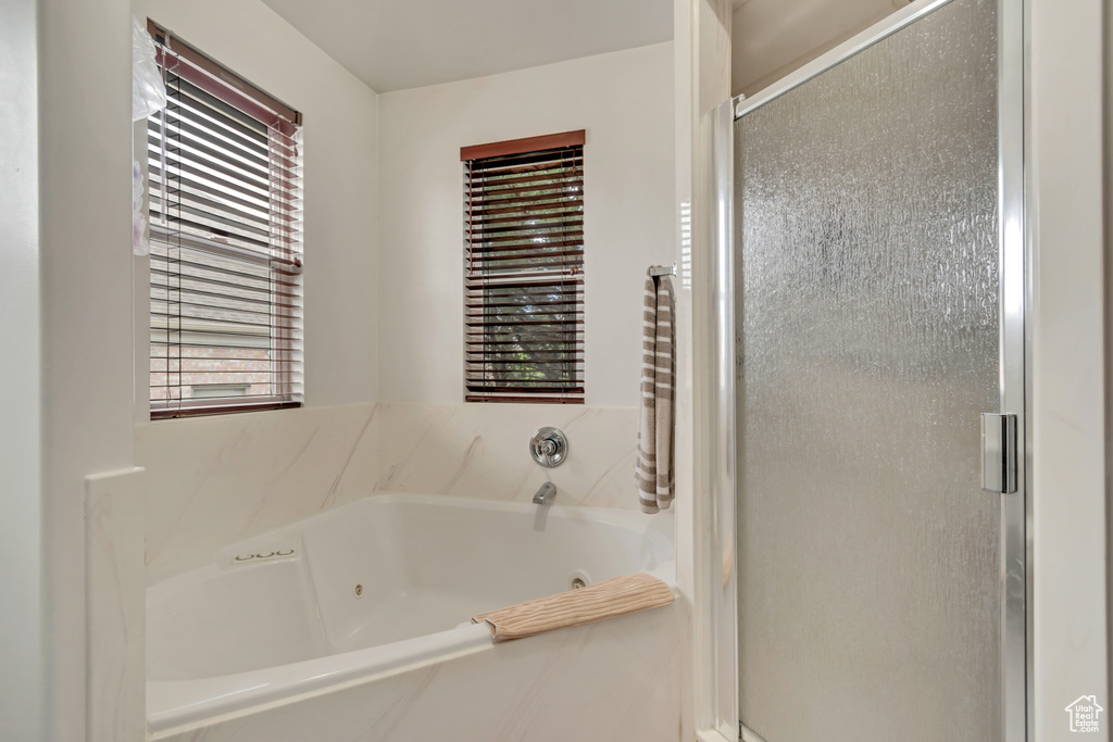 Bathroom featuring a stall shower and a whirlpool tub
