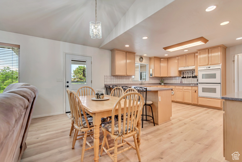 Dining space with a chandelier, light wood-style floors, recessed lighting, and baseboards