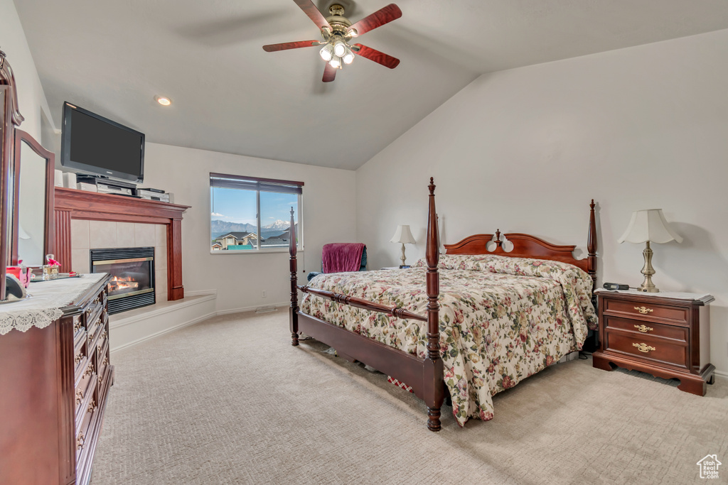 Carpeted bedroom featuring a fireplace, lofted ceiling, a ceiling fan, baseboards, and recessed lighting