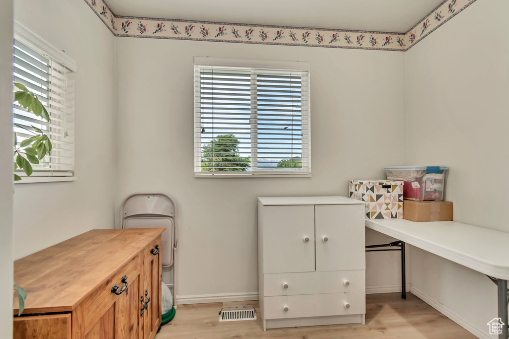 Office space with healthy amount of natural light, light wood finished floors, and baseboards