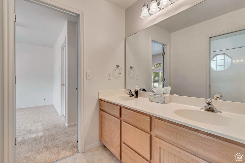 Full bathroom featuring double vanity and baseboards