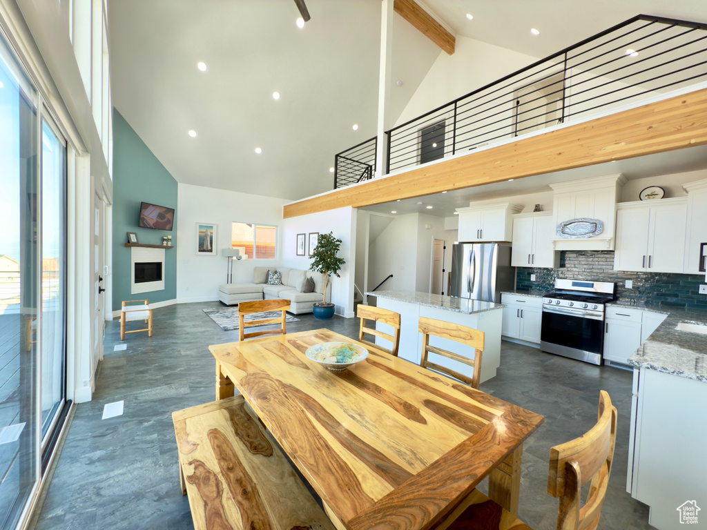 Dining space featuring beam ceiling and high vaulted ceiling