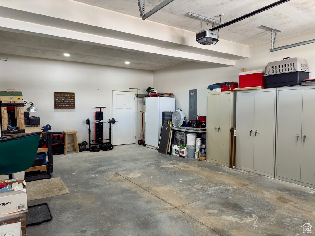 Garage featuring a garage door opener and electric panel