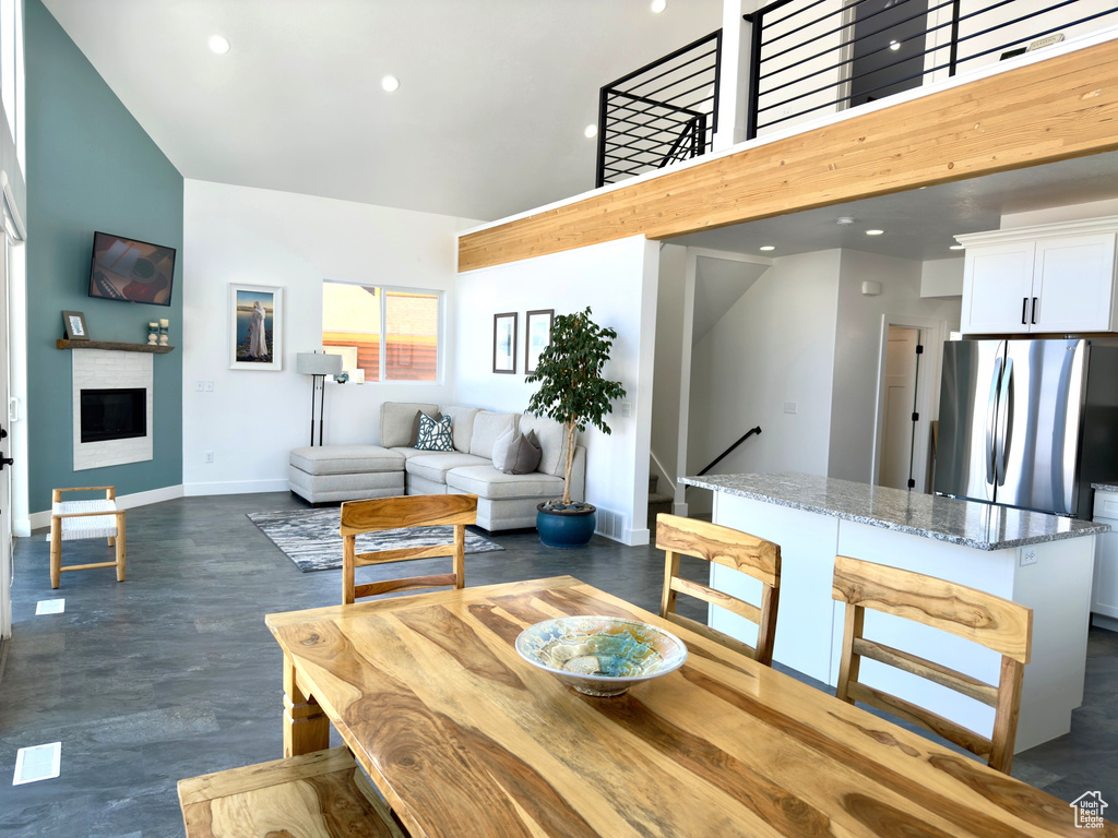 Dining area with a towering ceiling and a fireplace