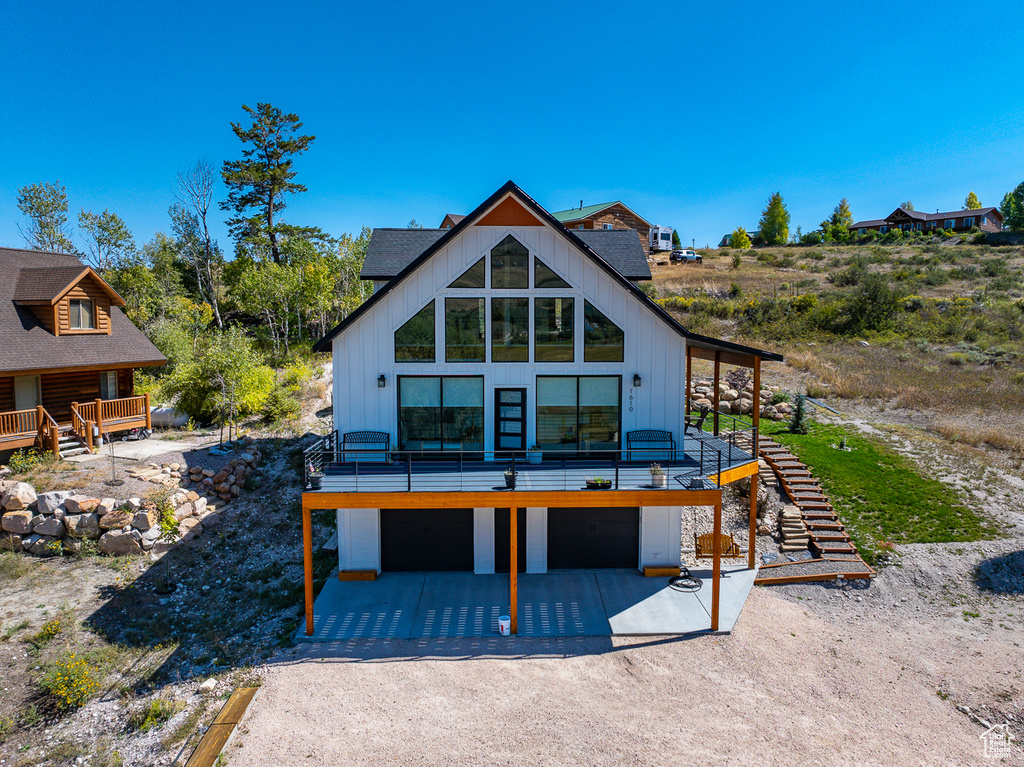 Rear view of property with a wooden deck and a garage