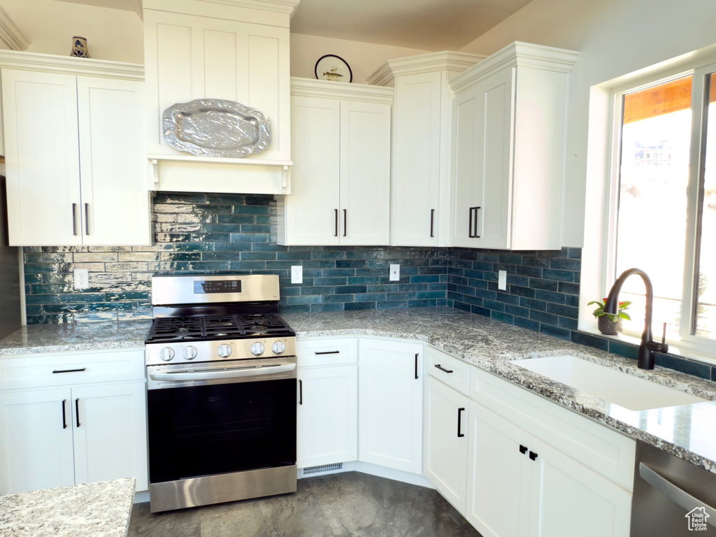 Kitchen featuring white cabinetry, sink, and appliances with stainless steel finishes